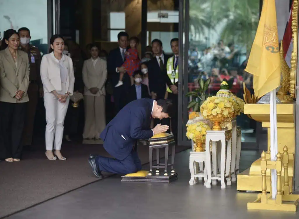 ‘ทักษิณ’ กลับไทย ก้มกราบพระบรมฉายาลักษณ์ ‘ในหลวง-ราชินี’ โบกมือทักทายมวลชนเสื้อแดง